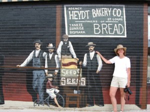 Neala Schwartzberg poses in front of the Prosperity Corner mural on the Hayes Shoe Store. See blog "If This Corner Could Talk."