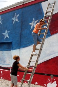 Suzie Haffer and Keli Portious of a Touch of Color in Steelville help out with mural maintenance.