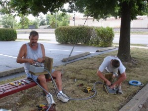 Workers take advantage of the shade while installing lights above the Civil War murals.