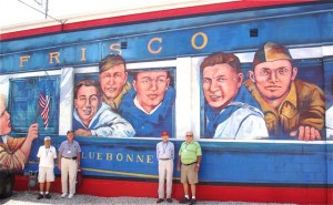 Veterans from the tour pose in front of the Gold Star boys mural.