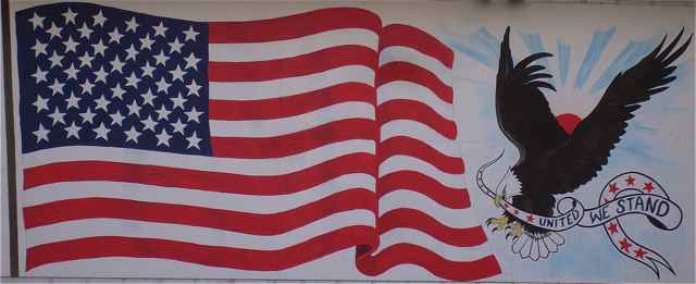 Local artist John Bland painted this after 9/11.  Today, this flag mural painted by local artist John Bland adorns the front of the East Office Bar & Grill. Maybe generations to come will be looking at this graphic to see what Cuba was like in 2009.
